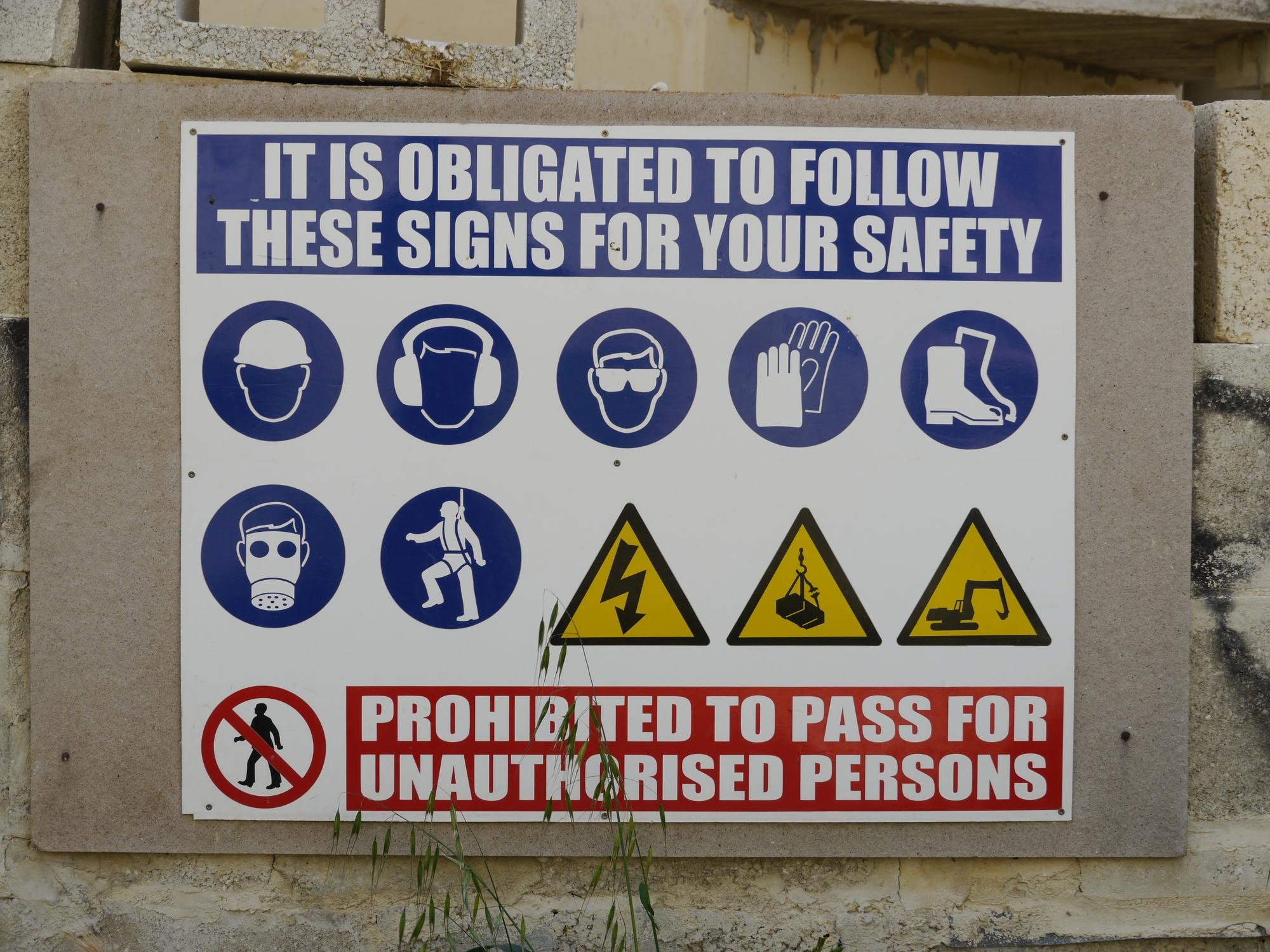 Mandatory PPE requirement signs at construction site entry