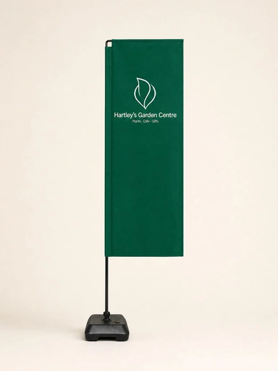 Green economy flag for Hartley's Garden Centre on a weighted base against a plain studio backdrop