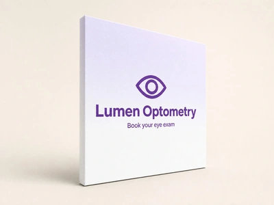White fabric pop-up stand for Lumen Optometry with purple eye logo on a plain studio backdrop