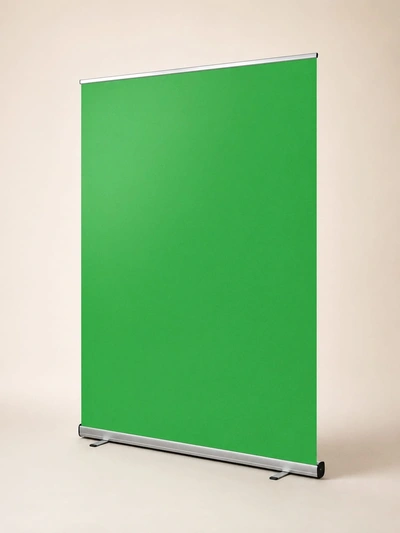 Pull-up green screen backdrop on an aluminium base against a plain studio wall