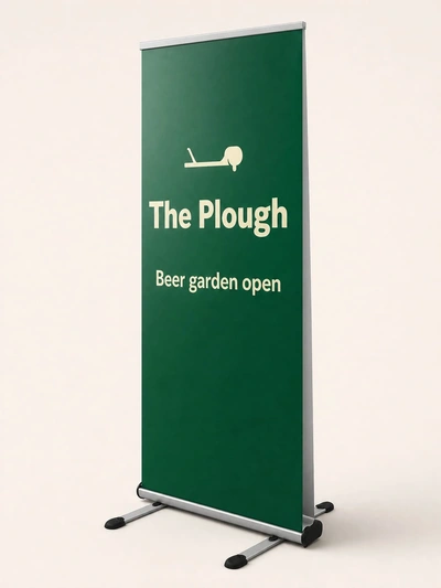 Green outdoor roller banner for The Plough pub's beer garden on a plain studio backdrop