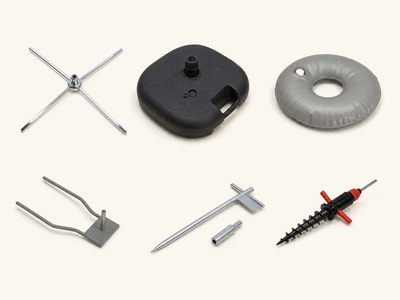 Flag accessories on a studio backdrop: cross base, weighted base, water ring, ground spike and screw