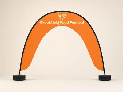 Orange arch event flag for Brookfield Food Festival with weighted bases on a plain studio backdrop