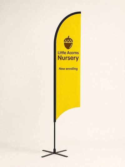 Yellow fin flag for Little Acorns Nursery on a cross base against a plain studio backdrop