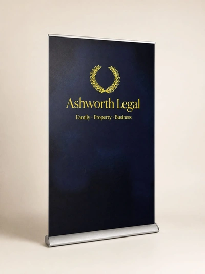 Navy premium roller banner for Ashworth Legal with gold wreath logo on a plain studio backdrop