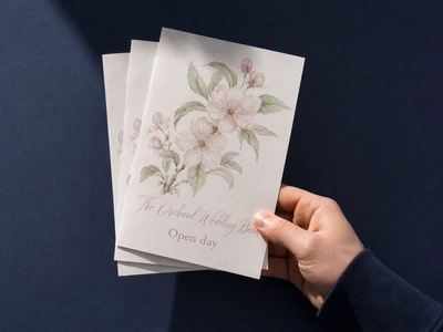 Pearl A5 flyers for The Orchard Wedding Barn fanned in one hand