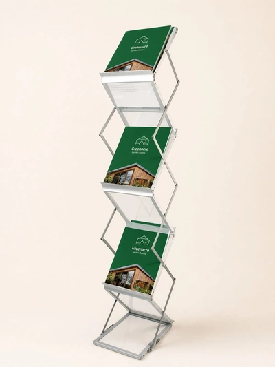 Folding literature stand holding Greenacre Garden Rooms brochures on a plain studio backdrop